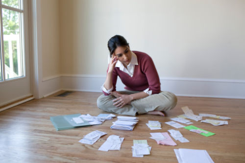 Woman on floor sorting financial documents