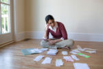 Woman on floor sorting financial documents